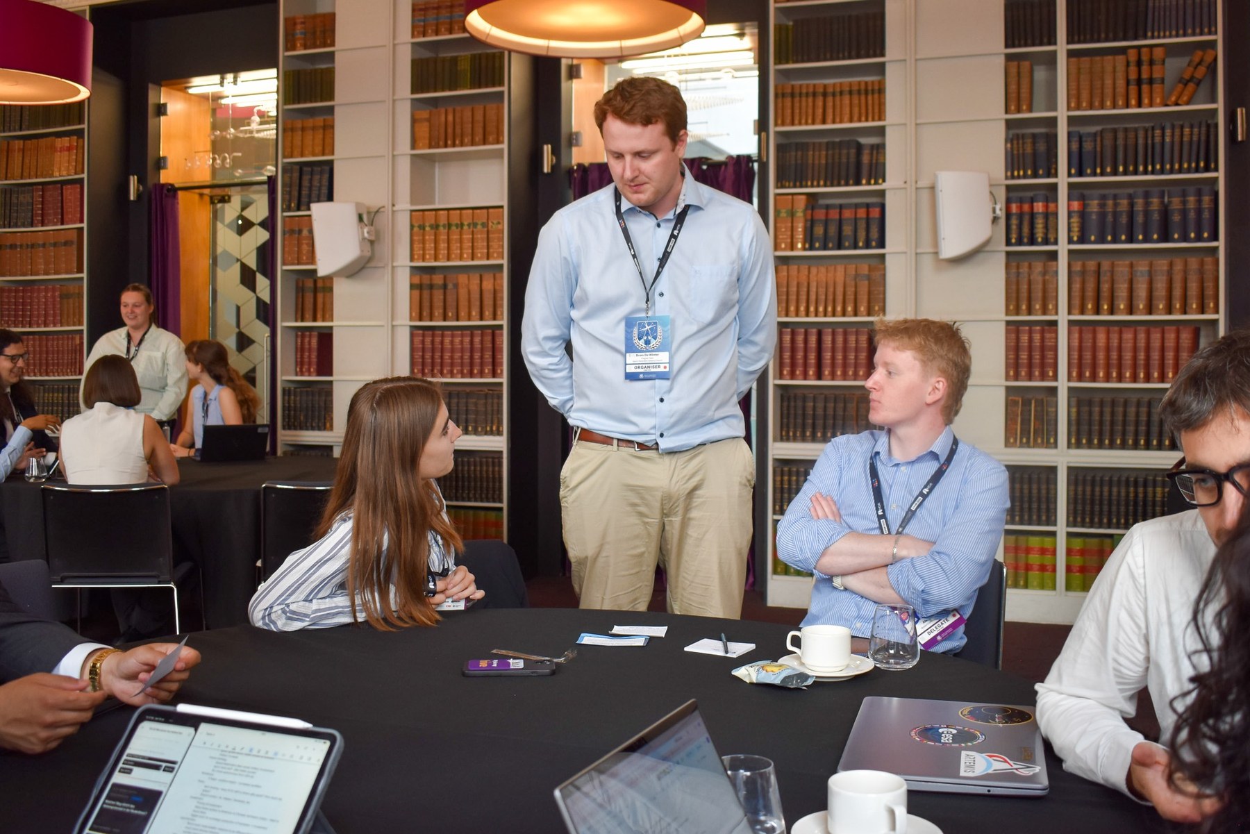 Bram de Winter speaking at a round table discussion in a library-style room
